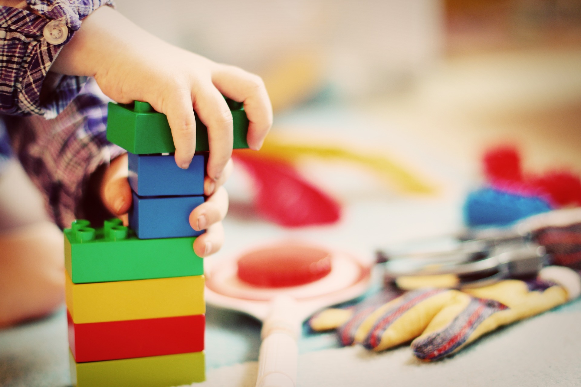 Eine Kinderhand hält Bauklötze