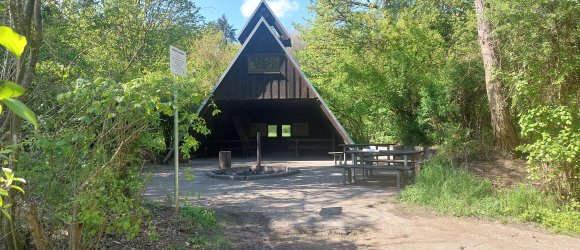Eine Grillhütte mit einer Feuerstelle davor