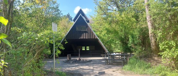 Eine Grillhütte mit einer Feuerstelle davor