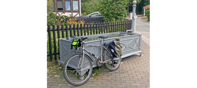 Ein Fahrrad, an einen Brunnentrog gelehnt