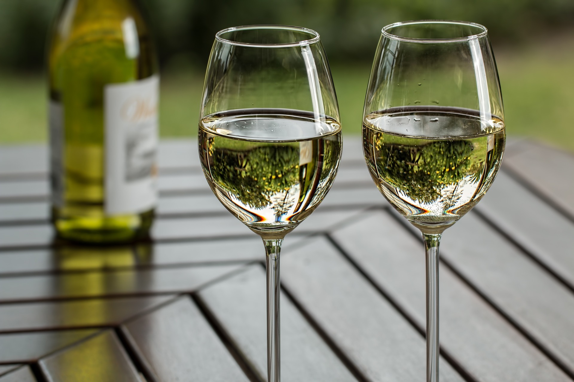 Zwei mit Weißwein gefüllte Gläser auf einem Holztisch