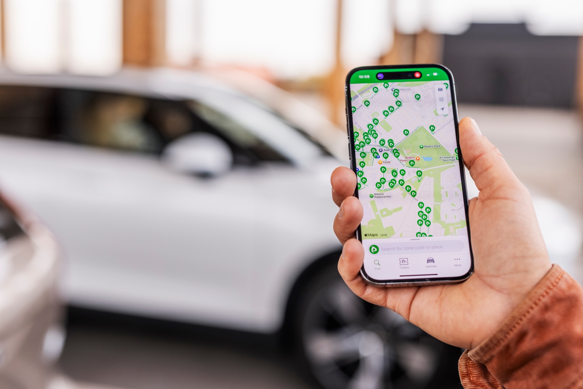 Eine Hand hält ein Mobiltelefon, auf dem die Parkster-App geöffnet ist