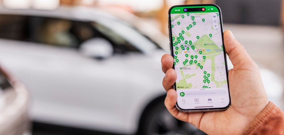 Eine Hand hält ein Mobiltelefon, auf dem die Parkster-App geöffnet ist