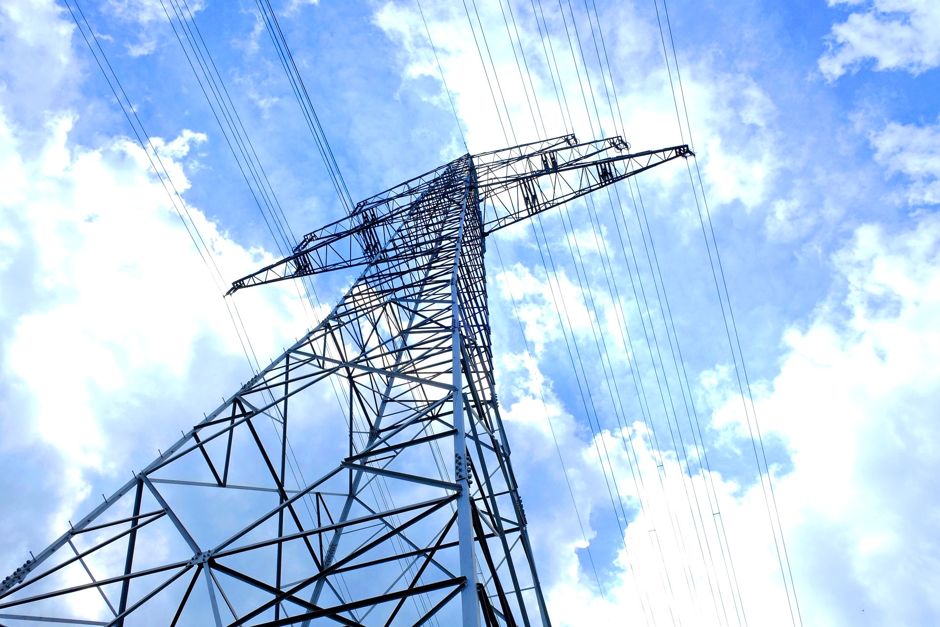 Ein Strommast vor wolkigem Himmel