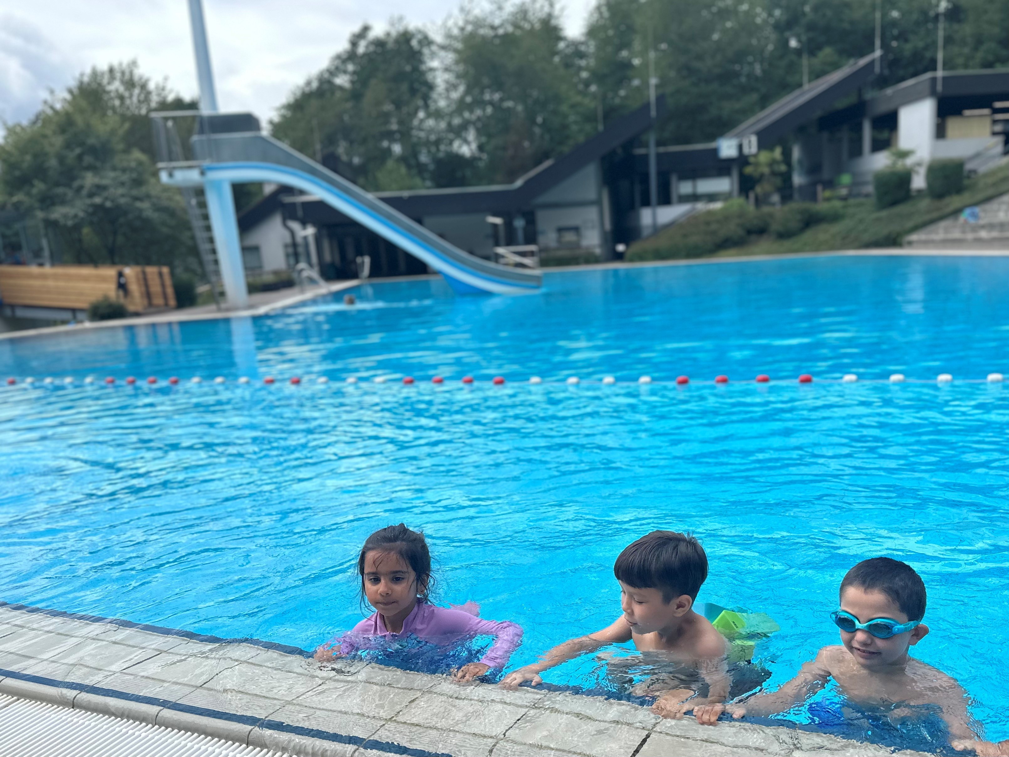 Drei Kinder in einem Schwimmbecken