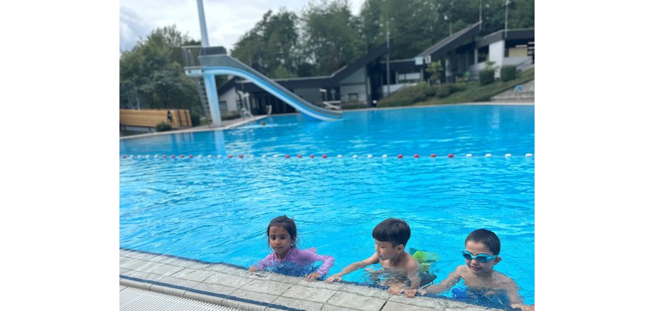 Drei Kinder in einem Schwimmbecken