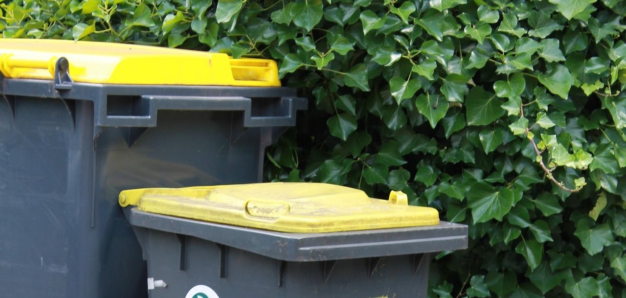 Zwei Mülltonnen mit gelben Deckeln