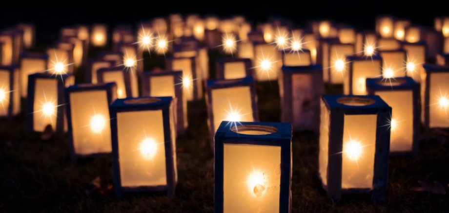 Mehrere leuchtenden Papierlaternen vor einem dunklen Hintergrund