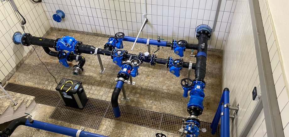 Blick in eine Aufbereitungsanlage für Trinkwasser: Durch einen hell gekachelten Raum verlaufen blaue Rohre